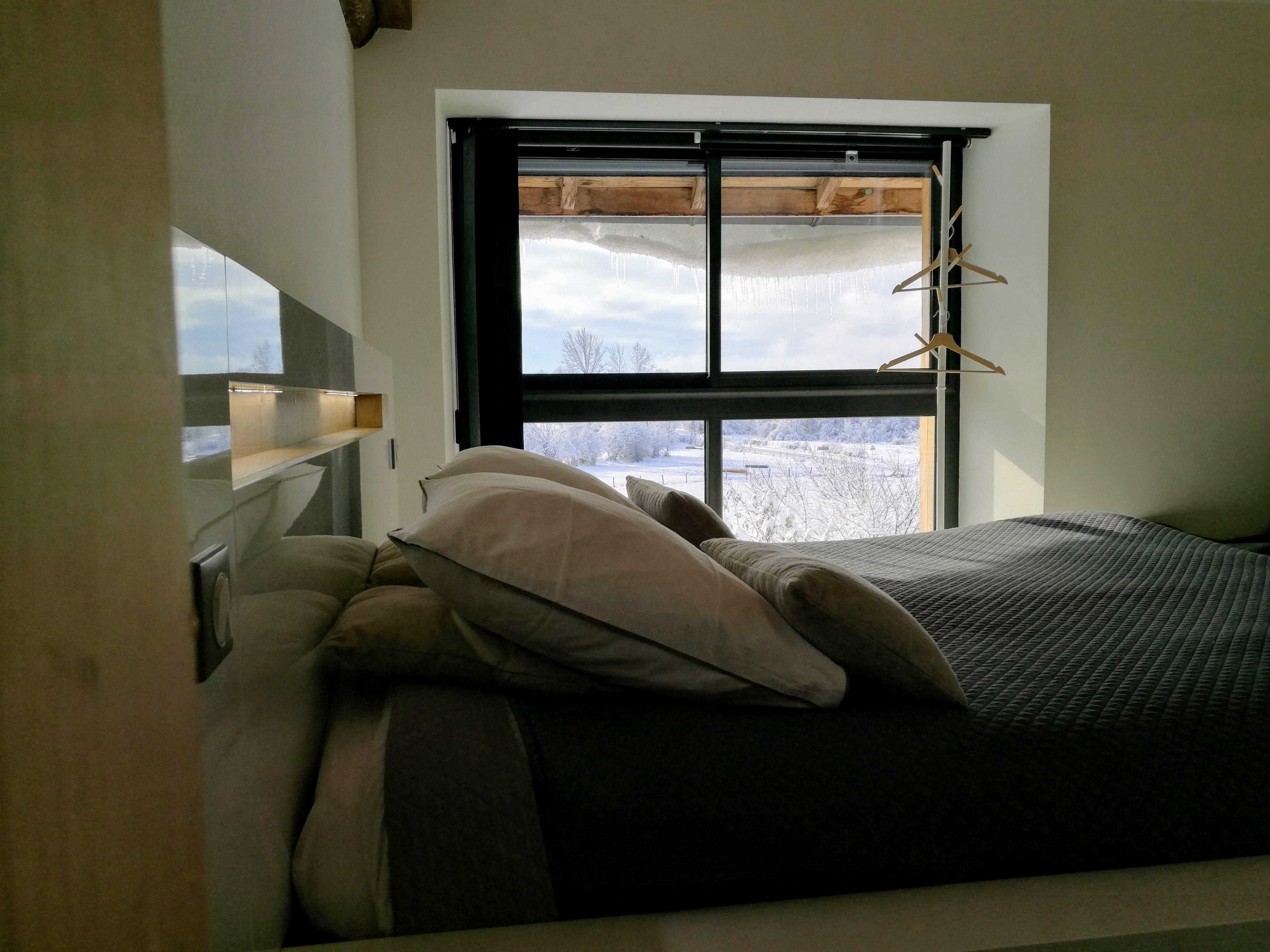 Chambre de la Ferme du Bois Joli avec paysage enneigé visible depuis la fenêtre