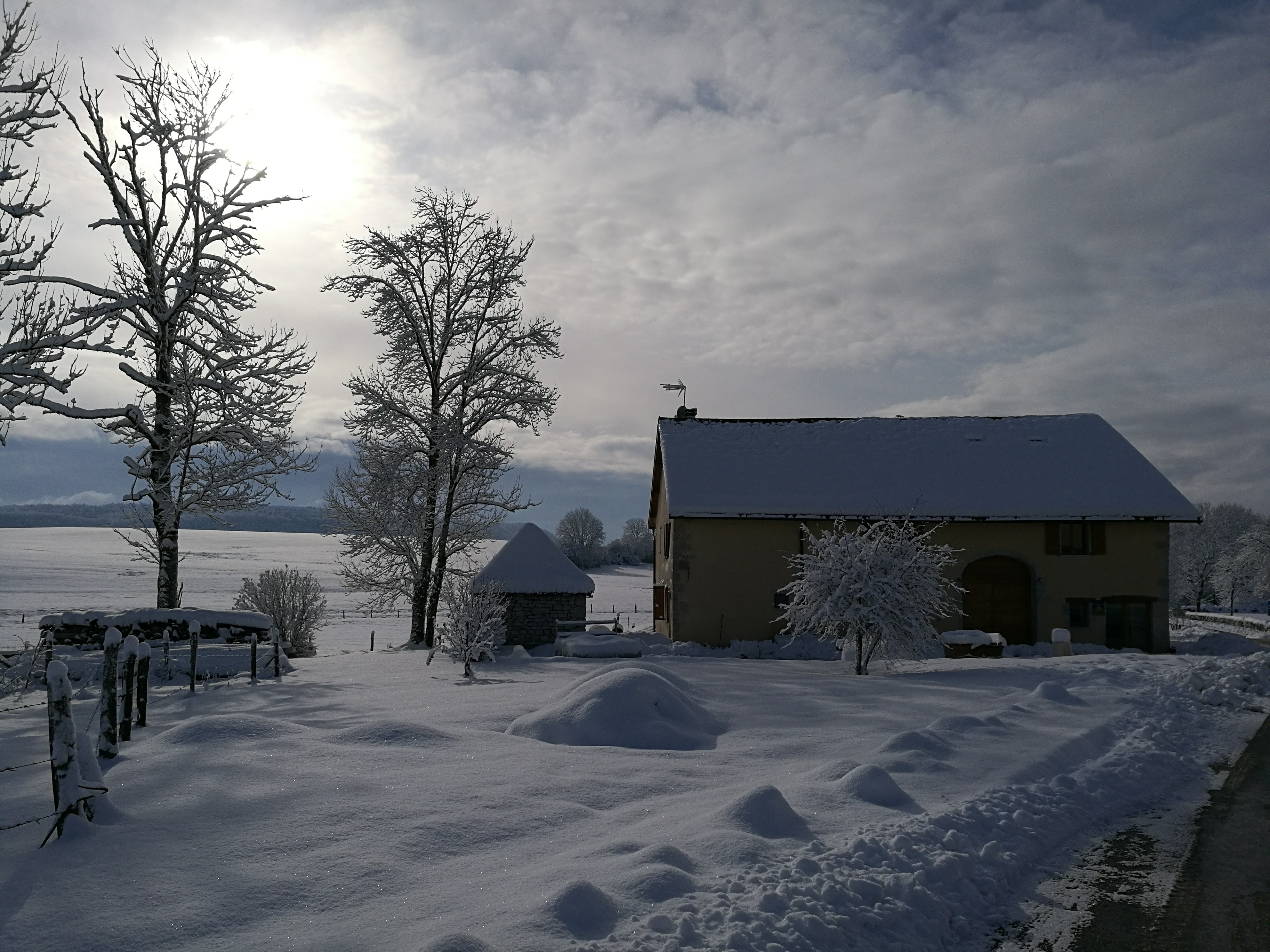 La Ferme du Bois Joli et les prairies enneigées en hiver