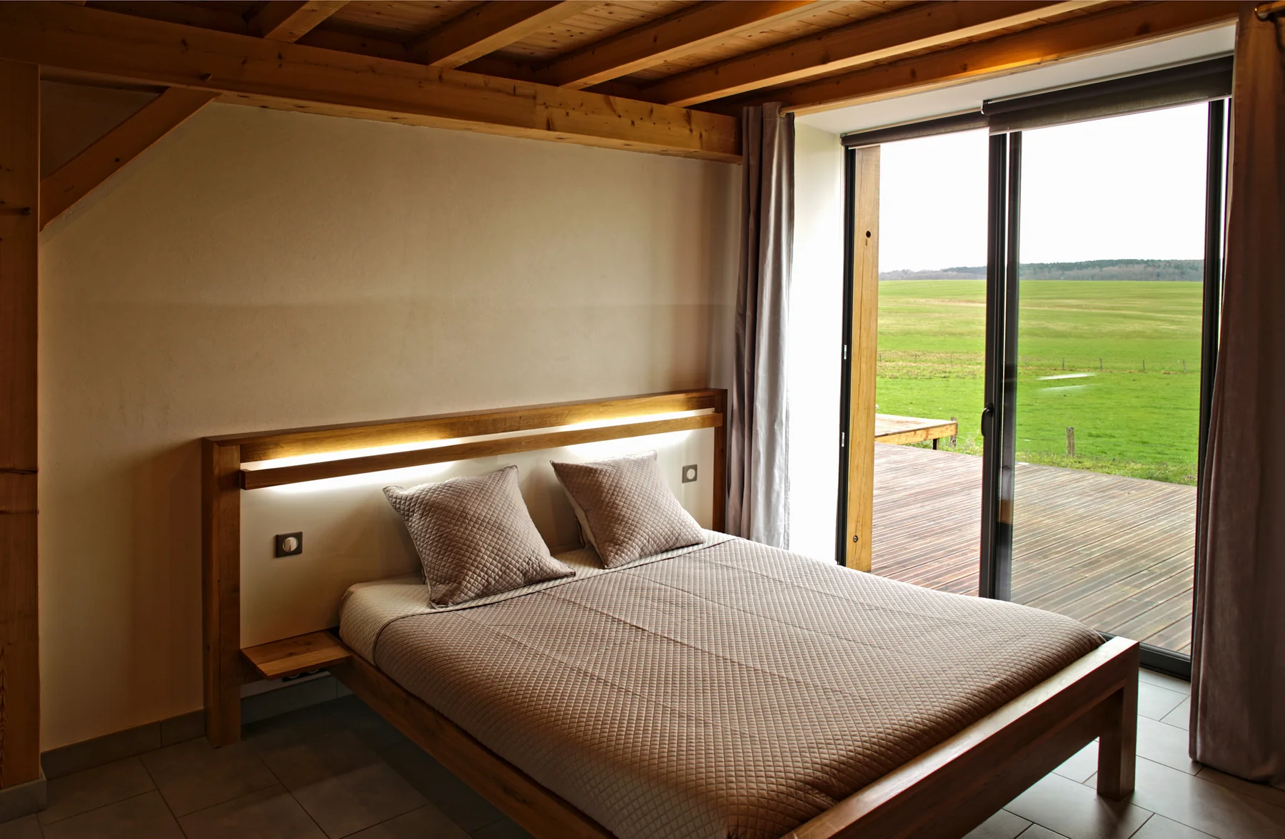 Chambre en bois avec lit double au Ferme du Bois Joli